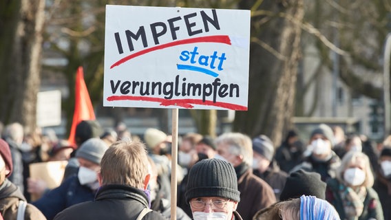 Auf einem Plakat bei einer Demo gegen Corona-Leugner in Hamburg steht "Impfen statt verunglimpfen". © picture alliance/dpa Foto: Georg Wendt