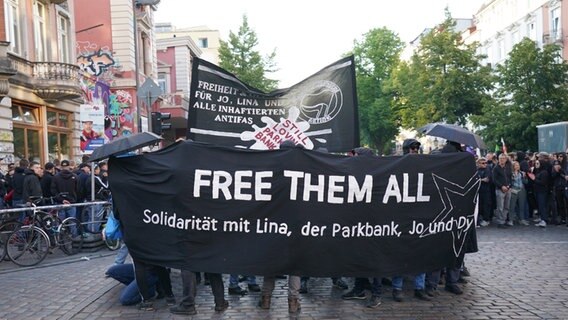 Zahlreiche Menschen haben sich zu einer Demonstration vor der Roten Flora im Hamburger Schanzenviertel versammelt. Auf einem Transparent steht "Free them all". © picture alliance / dpa Foto: Marcus Brandt