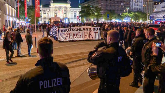 Polizisten blicken auf einen Demonstrationszug der linken Szene in Hamburg. © TeleNewsNetwork 