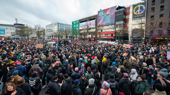 Zahlreiche Demonstranten stehen mit Plakaten auf der Reeperbahn vor dem Musikclub "Molotow". © Jonas Walzberg/dpa Foto: Jonas Walzberg