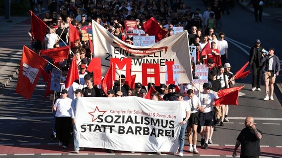 Teilnehmer halten Banner während der "revolutionären 1. Mai Demonstration". Die Demonstration hat das Motto "Eine Welt zu gewinnen". © dpa Foto: Marcus Brandt