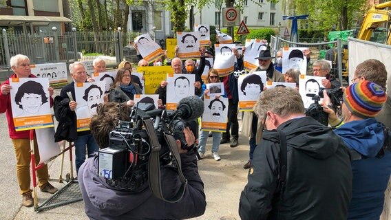 Mehrere Personen halten bei einer Kundgebung Plakate in den Händen. © NDR Foto: Andreas Gaertner