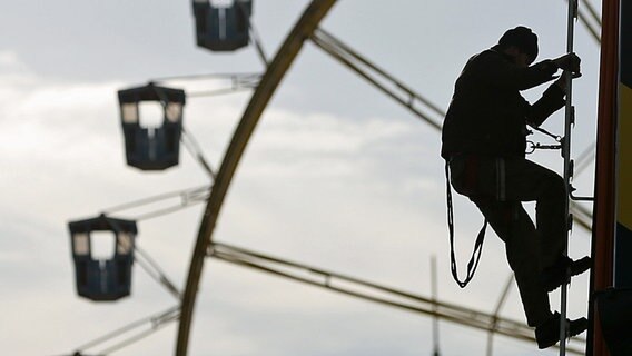 Letzte Arbeiten beim Aufbau eines Fahrgeschäftes auf dem Hamburger Dom. © dpa Foto: Christian Charisius
