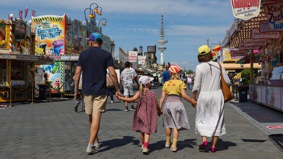 Eine Familie schlendert über den Hamburger Sommerdom. © picture alliance / dpa Foto: Ulrich Perrey