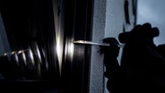 Ein Einbrecher versucht mit einem Brecheisen, ein Fenster aufzubrechen. (Gestellte Szene) © picture alliance / Fotostand | Fotostand / K. Schmitt 