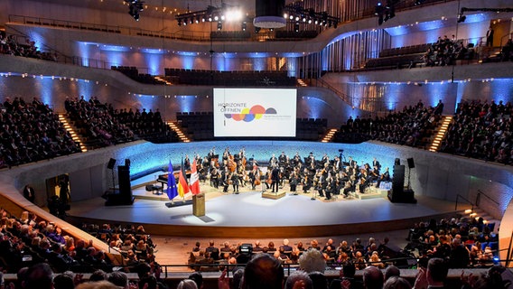 Menschen besuchen einen Festakt anlässlich der Feierlichkeiten zur deutschen Wiedervereinigung in der Elbphilharmonie. © Gregor Fischer/Pool AP/AP 