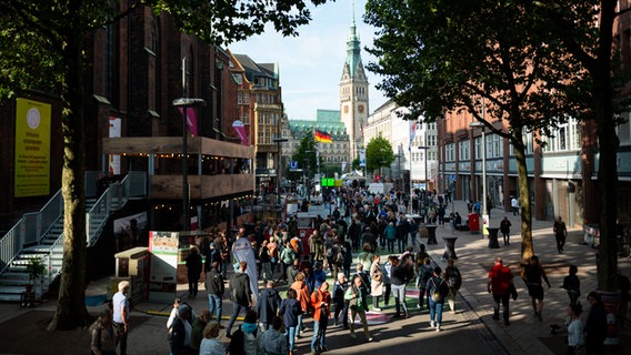 Besucher laufen am Tag der Deutschen Einheit in Hamburg auf der Ländermeile vor dem Rathaus über die Mönckebergstraße. © picture alliance / dpa Foto: Jonas Walzberg