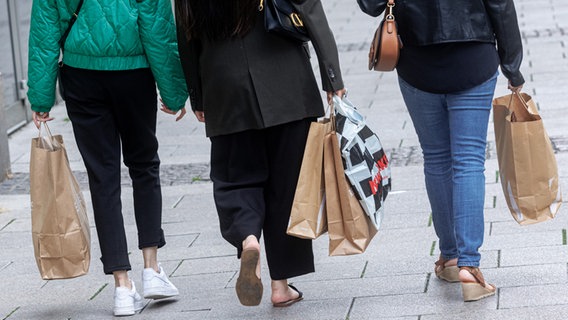 Frauen gehen am verkaufsoffenen Sonntag mit ihren Einkaufstaschen über den Hamburger Rathausmarkt. © picture alliance / dpa Foto: Markus Scholz