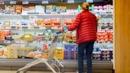 Eine Kundin steht mit ihrem Einkaufswagen im Supermarkt vor einem Kühlregal. © picture alliance/dpa | Markus Scholz Foto: Markus Scholz