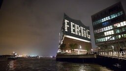 Durch unterschiedlich beleuchtete Fenster ist auf einer Fassade der Elbphilharmonie  in Hamburg das Wort "Fertig" zu lesen. © dpa-Bildfunk Foto: Christian Charisius