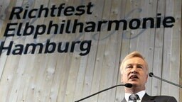 Hamburgs Bürgermeister Ole von Beust bei einer Rede während des Richtfestes für die Elbphilharmonie. © dpa Foto: Maurizio Gambarini