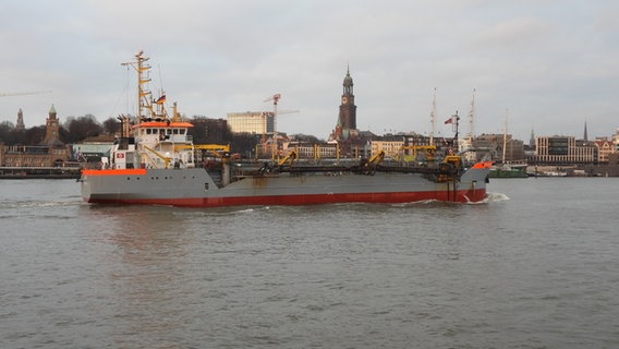 Das mit Hafenschlick beladene Baggerschiff "Amazone" vor dem Hamburger Hafen und dem Michel. © radio tele nord Foto: Frank Bründel
