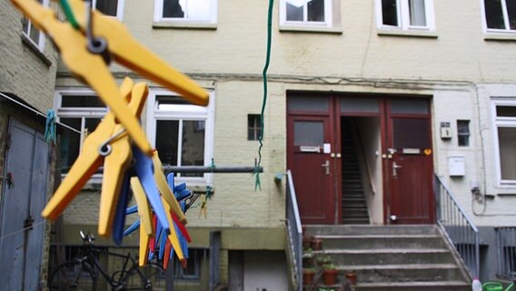 Eine Leine mit Wäscheklammern hängt vor dem Eingang eines Elbtreppenhauses. © NDR Foto: Daniel Sprenger