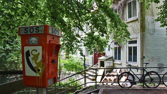 Eine Notrufsäule mit der Aufschrift "SOS" steht vor den historischen Elbtreppenhäusern. © NDR Foto: Daniel Sprenger