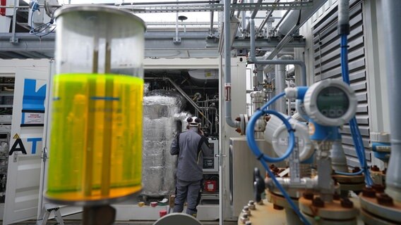 Ein Mitarbeiter überprüft die neue Power-to-Liquid-Demonstrationsanlage auf dem Gelände der Raffinerie H&R Ölwerke Schindler GmbH im Hamburger Hafen. © picture alliance/dpa | Marcus Brandt 