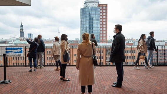 Besucher stehen auf der Plaza der Elbphilharmonie. Die Elbphilharmonie-Plaza wurde nach coronabedingter Pause wieder geöffnet. © picture alliance/dpa Foto: Georg Wendt