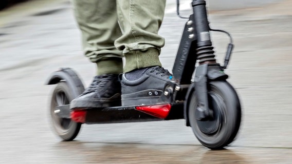 Füße stehen auf einem fahrenden E-Scooter. © picture alliance / dpa Foto: Christoph Soeder