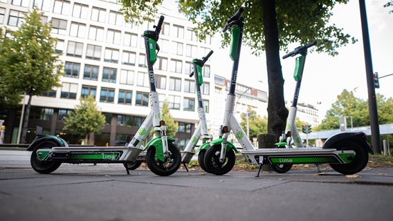 Mehrere Elektro-Scooter stehen auf einem Gehweg in Hamburg. © dpa Foto: Daniel Reinhardt