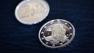 Zwei neue Zwei-Euro-Münzen mit der Silhouette der Elbphilharmonie. © dpa Foto: Christian Charisius