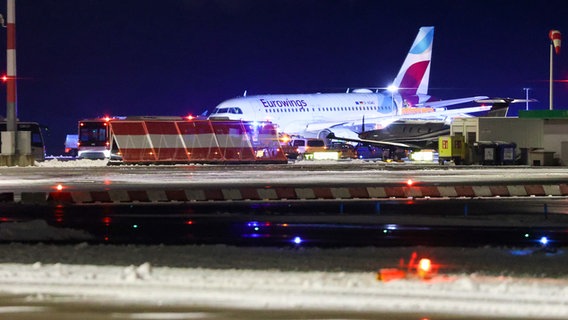 Eine Maschine der Fluggesellschaft Eurowings steht abseits der Terminals auf dem Hamburger Flughafen. Sie soll bei Glatteis von der Piste in den Grünstreifen gerutscht sein. © picture alliance / dpa Foto: Bodo Marks