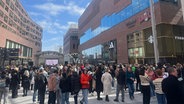 Menschen stehen bei der Evakuierung des Westfields vor dem Einkaufszentrum. © NDR Foto: Marc-Oliver Rehmann