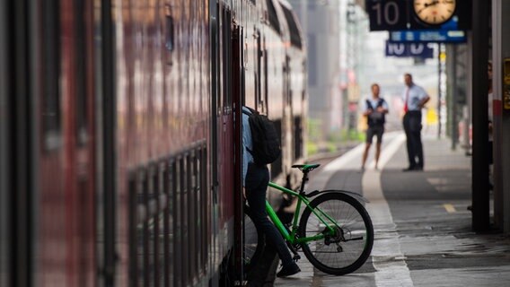 Ein Mann steigt mit seinem Fahrrad in den Zug. © picture alliance/dpa | Andreas Arnold Foto: Andreas Arnold