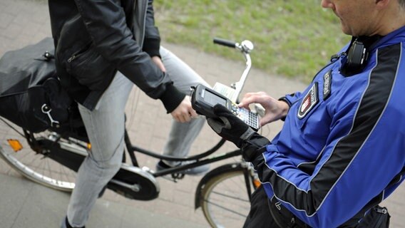 Ein Hamburger Polizist kontrolliert einen Radfahrer. © picture alliance / dpa Foto: Angelika Warmuth