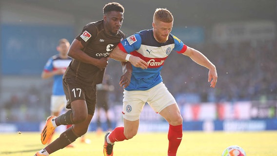 Oladapo Afolayan (FC St. Pauli) im Duell um den Ball gegen Mikkel Kirkeskov (Holstein Kiel) © IMAGO Foto: MIS