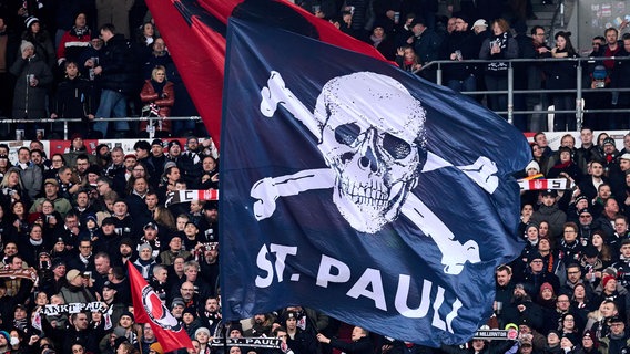 Fans des FC St. Pauli schwenken große Vereinsflaggen. © Eibner-Pressefoto Foto: Stephanie Zerbe