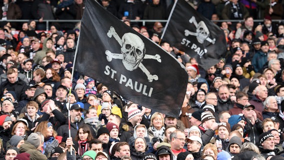 Fans des FC St. Pauli schwenken große Vereinsflaggen. © picture alliance/dpa | Daniel Bockwoldt Foto: Daniel Bockwoldt