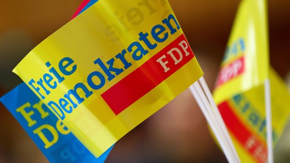 Fähnchen mit dem FDP-Logo stehen auf einem Tisch. © picture alliance / dpa Foto: Daiel Karmann