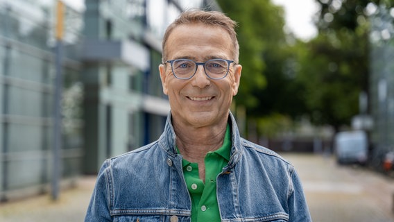 Dr. Matthias Riedl, der als Gast für den Feel Hamburg-Podcast interviewt wird, steht auf dem NDR-Gelände am Rothenbaum. © NDR Foto: Frederike Burgdorf