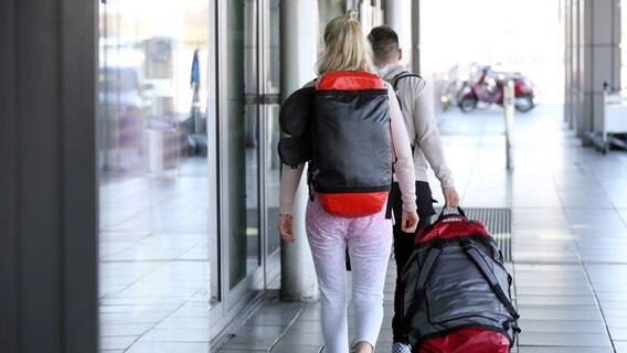Zwei junge Reisende mit ihren Koffern am Hamburger Flughafen. © imago images/Nikita Foto: imago images/Nikita