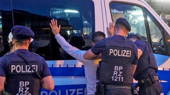 Beamte der Bundespolizei durchsuchen einen Mann am Hamburger Hauptbahnhof. © picture alliance / 