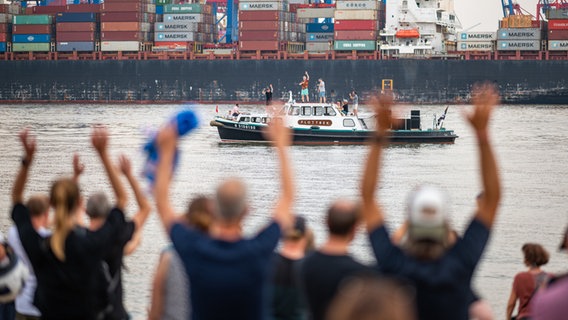 Die Band Fettes Brot tritt auf einem Boot auf der Elbe vor dem Elbstrand auf. © Daniel Reinhardt/dpa 