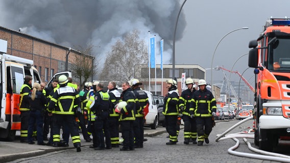 Feuerwehrleute besprechen sich in der Nähe eines Großbrandes in Hamburg-Rothenburgsort. © Jonas Walzberg/dpa 
