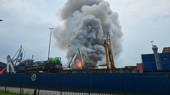 Eine dichte Qualmwolke steigt über den Flammen eines brennenden Recyclinghofes im Hamburger Hafen auf. © HamburgNews 