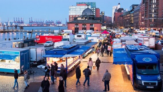 Besucher gehen am Morgen über den Hamburger Fischmarkt an der Elbe. © picture alliance / dpa Foto: Daniel Bockwoldt