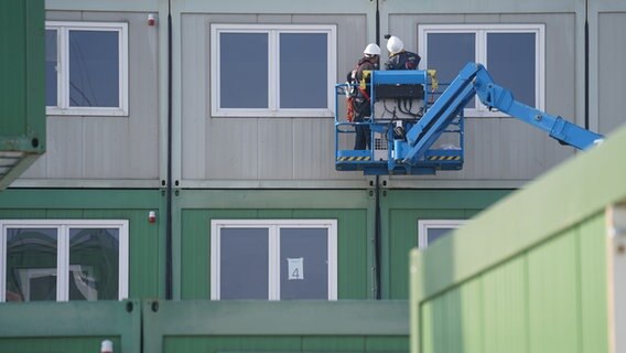 Arbeiter stellen Wohncontainer für ukrainische Flüchtlinge an der Schnackenburgallee in Hamburg auf. © dpa Foto: Marcus Brandt