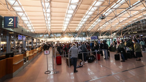 Reisende stehen in langen Schlangen vor den Check-In-Schaltern in Terminal 1 am Flughafen. © picture alliance/dpa | Christian Charisius Foto: Christian Charisius