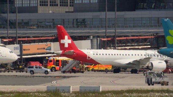 Einsatzfahrzeuge der Flughafen-Feuerwehr stehen neben einem Flugzeug. © TV Newskontor 