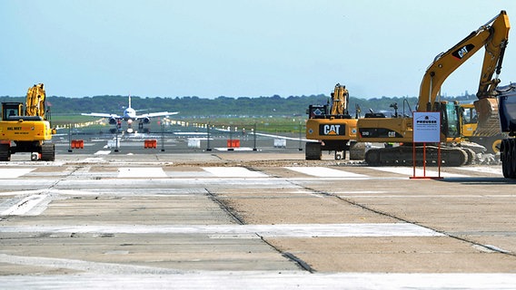 Baumaschinen arbeiten in Hamburg am Flughafen an der Erneuerung einer Start- und Landebahn. © dpa Foto: Angelika Warmuth