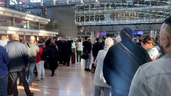 Aufgrund eines Streiks stehen mehrere Personen am Hamburger Flughafen in Warteschlagen. © NDR Foto: Anna Rüter