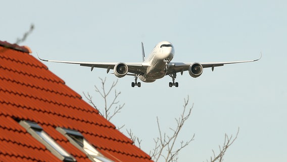 Ein Flugzeug im Anflug über Hamburger Hausdächer. © picture alliance / PublicAd Foto: Mirko Hannemann