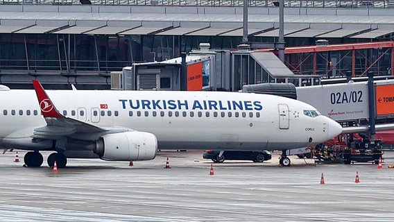 Auf dem Vorfeld des gesperrten Hamburger Flughafens steht eine Maschine der Turkish Airlines. Hinter der Maschine steht ein Auto, in dem der mutmaßliche Geiselnehmer mit seinem Kind sitzen soll. Ein bewaffneter Mann hält auf dem Airport seine vierjährige Tochter in seiner Gewalt. © picture alliance / dpa Foto: Jonas Walzberg