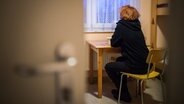 Eine Frau blickt in einem Frauenhaus aus dem Fenster. © picture alliance/dpa Foto: Sophia Kembowski