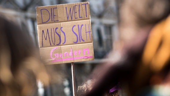 "Die Welt muss sich gendern" steht auf einem Plakat bei der Weltfrauentagsdemo in Hamburg. "Die Welt muss sich gendern" steht auf einem Plakat bei der Weltfrauentagsdemo in Hamburg.