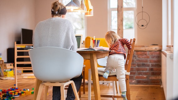 Eine Frau betreut ein Kind an einem Tisch. © picture alliance/dpa Foto: Julian Stratenschulte