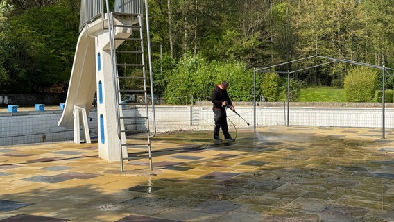 Ein Mann kärchert den Beckenboden im Freibad Blankenese. © NDR/Anna Rüter 