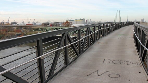 Auf eine Fahrradbrücke im Freihafen ist ein Graffiti mit dem Text "Border no" gemalt. © NDR Foto: Daniel Sprenger